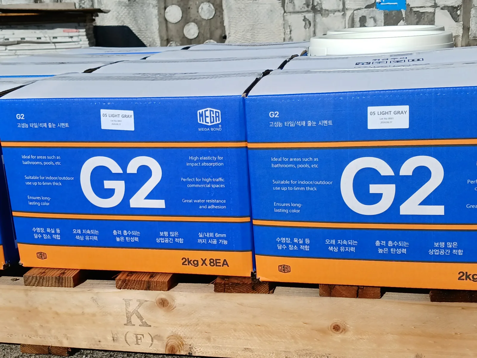 라이트그레이 컬러로 표기된 MEGA G2 줄눈시멘트 박스가 나란히 쌓인 클로즈업 사진
